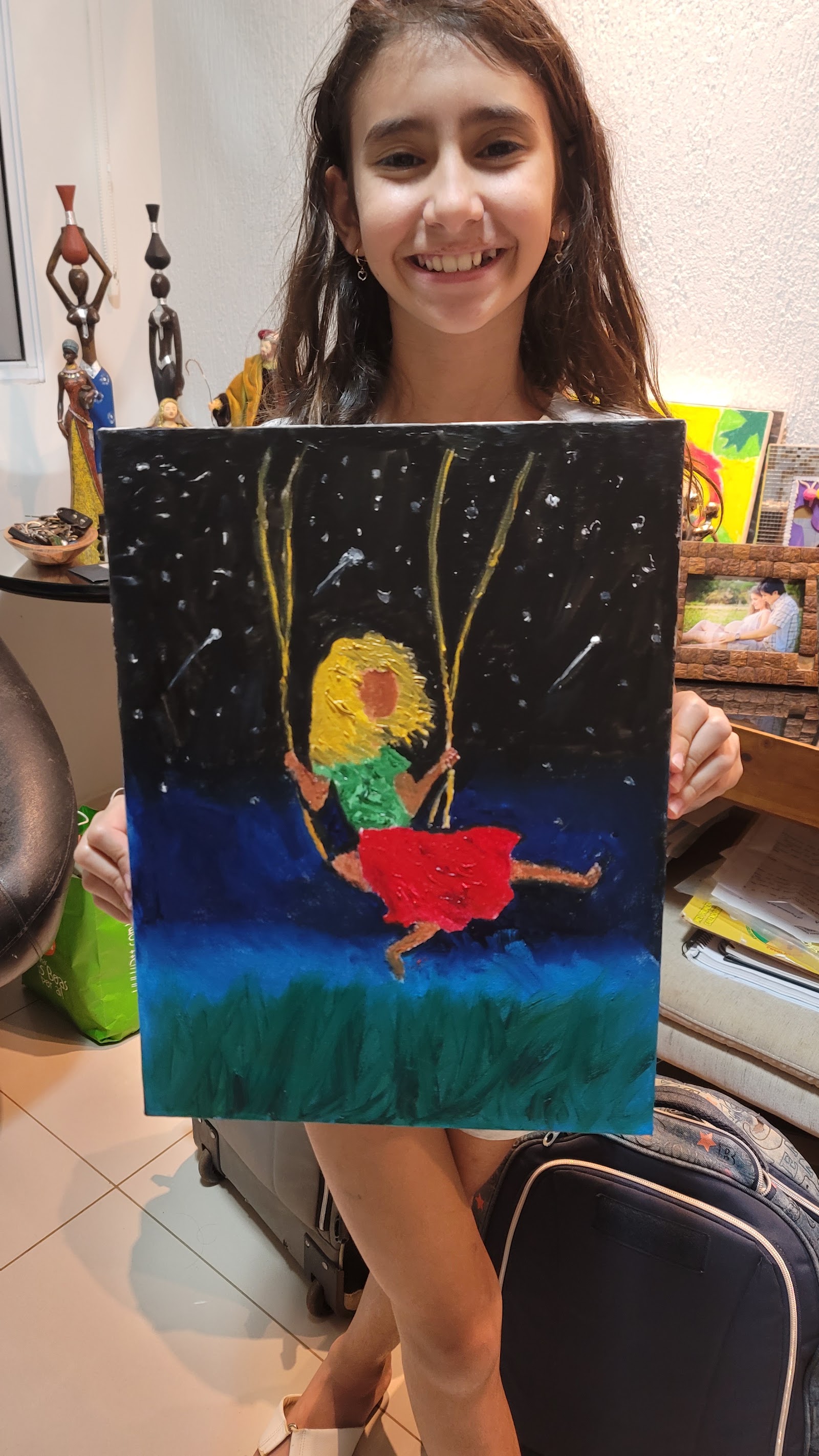 Helena Richter segurando a obra Infância finalizada